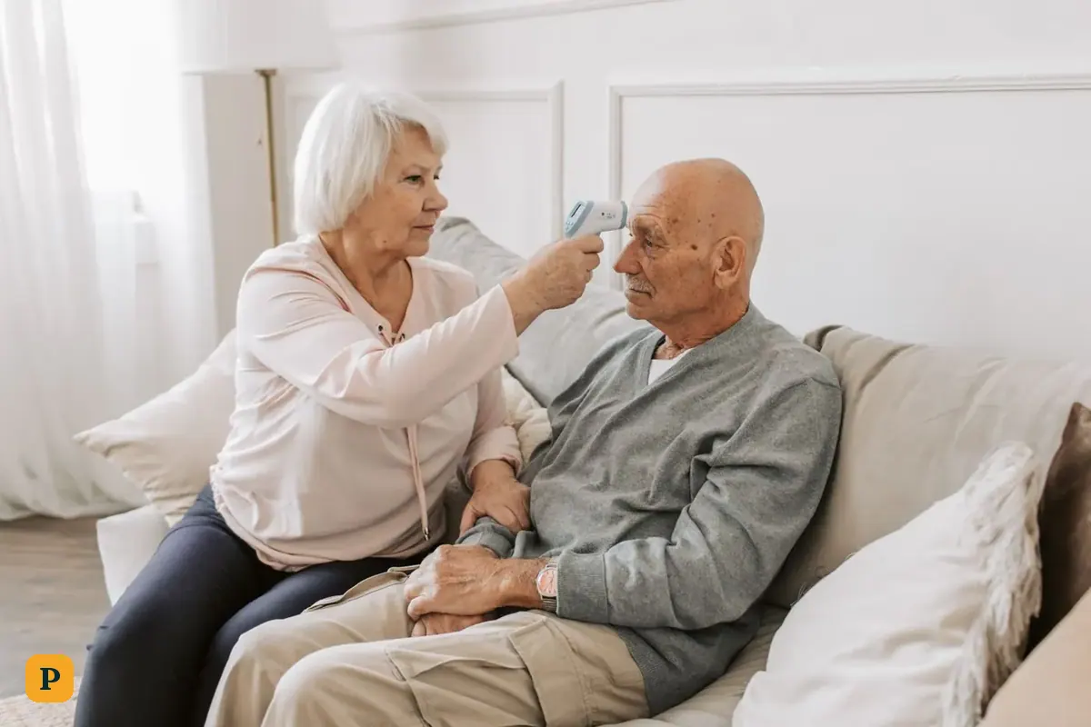 An older woman checks her husband's temperature at home