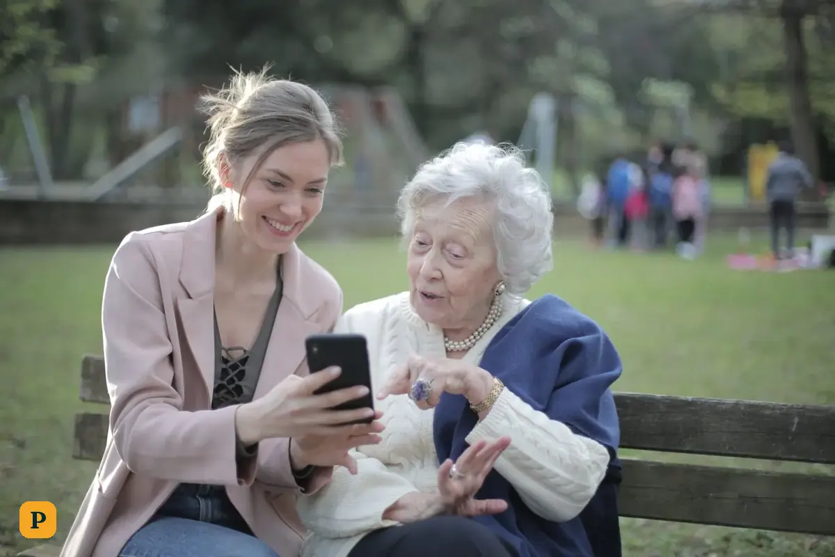 A mother and her adult daughter look at a phone together