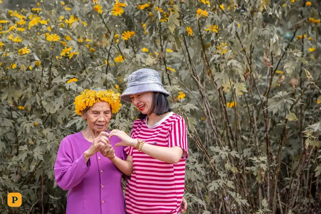 Cụ bà và một phụ nữ trẻ bên nhau trong vườn hoa